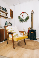 County house kitchen interior, with armchair and fireplace, cosy winter decoration.
