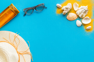 Flatlay of summer beach accessories with sand and seashells