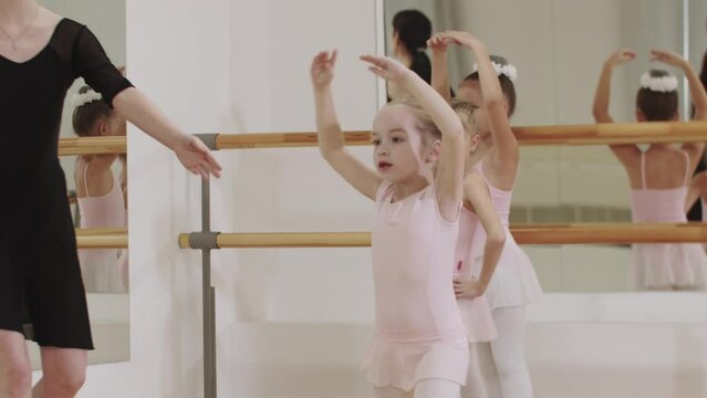 Ballet training - three little girls on ballet training with their trainer in mirror studio