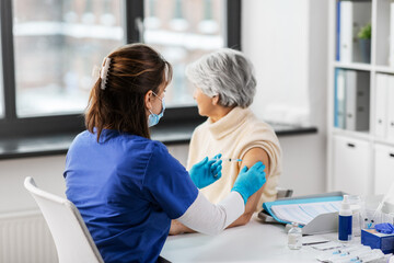 medicine, health and vaccination concept - doctor or nurse with syringe making vaccine or drug...