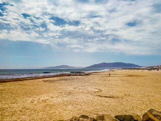 Atlantic Ocean. Spanish coast. Sand beach. Lots of sky and beach. Fresh sea air. Vacation on the seas. Landscape of the sea coast. Islands on the horizon. Footprints in the sand.