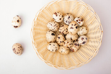 quail eggs in a shell in a basket on a light background