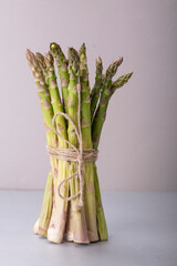 a bunch of asparagus on a table against a light background