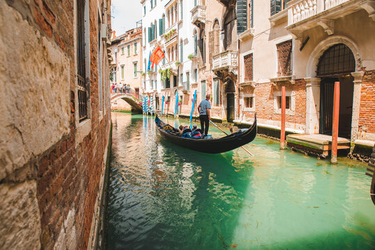 Italy, Venice - May 25, 2019: people at gondola taking tour by canal