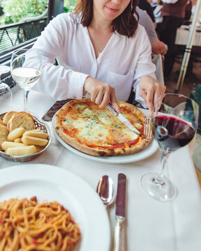 crop picture of woman in restaurant eating pizza drinking wine