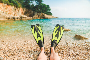 woman legs in flippers at beach sea on background