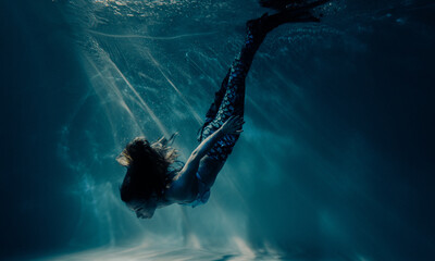 Woman with mermaid tail swims and dives underwater. - obrazy, fototapety, plakaty