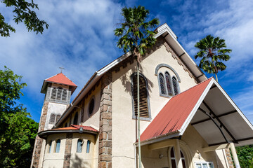 St Anne’s Catholic Church in Baie Ste Anne, Praslin Island, Seychelles, white colonial style church building with palm trees.
