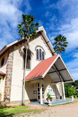 St Anne’s Catholic Church in Baie Ste Anne, Praslin Island, Seychelles, white colonial style church building with palm trees.