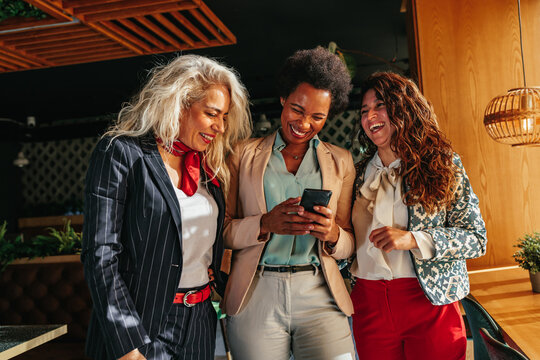 Three Diverse Women Using Mobile Phone Together