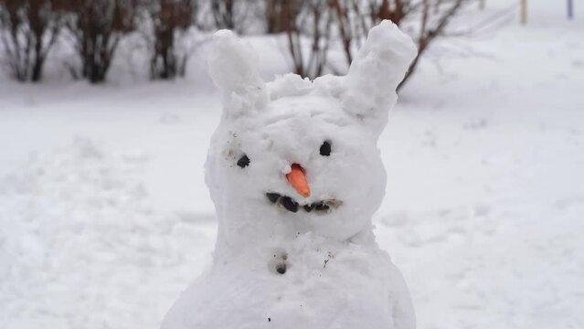 Ugly melting snowman with carrot nose and messy snow