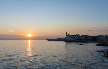 Obraz premium Picturesque sea evening landscape. Sunset over the mediterranean sea. Evening city, sea and sunset. The sun is above the horizon line.