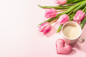 Romantic flat lay composition with a cup of coffee, soft felt hearts, and fresh tulips