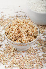Green sprouted buckwheat in a porcelain bowl on a white background. Flat copy space from above. Healthy vegan food, eco food, diet, organic. Harvest season of new life