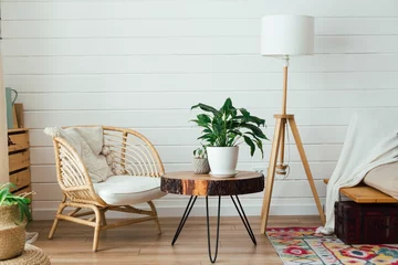Fotobehang Boho Rattan armchair and floor lamp in living room interior with plants. Cozy interior in boho style. Real photo  © lizaelesina