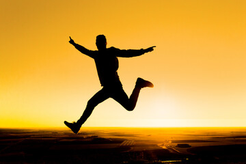 silhouette of a person jumping at sunset. Freedom and joy