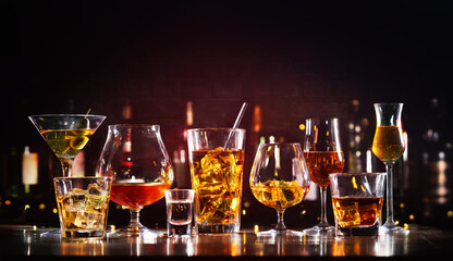 Assortment of hard strong alcoholic drinks and spirits in glasses on bar counter - obrazy, fototapety, plakaty