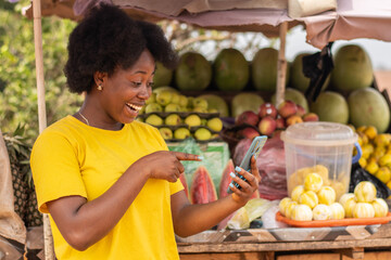 happy african lady points to her phone