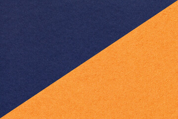 Texture of navy blue and orange paper background, half two colors, macro. Structure of indigo kraft...