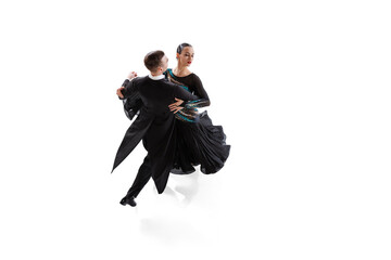 One young graceful artistic couple, man and woman dancing ballroom dance isolated over white studio background. Beauty, art, sport concept - obrazy, fototapety, plakaty