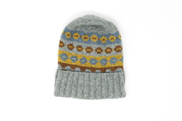 Fair Isle wool knitted hat in blue grey and yellow and brown with folded rib brim, flat lay isolated on white background