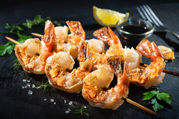 Grilled shrimp skewers served on black plate