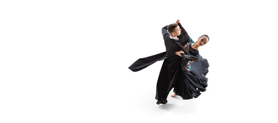 Aerial view of young graceful artistic couple, man and woman dancing waltz isolated over white...
