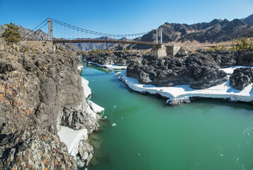 Bridge across the Katun River in the Altai Mountains, sunny day in early spring, travel and vacation