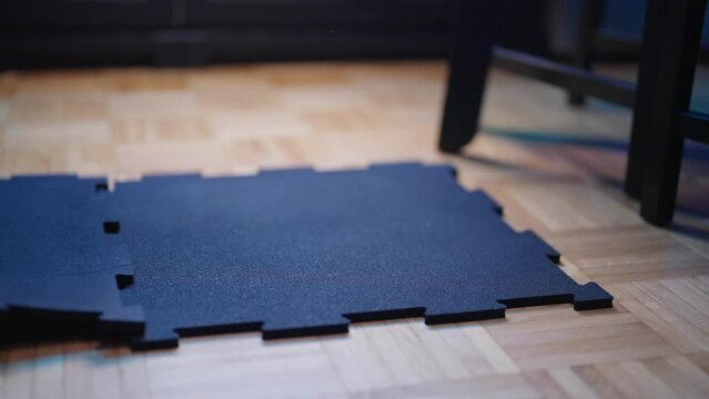 Person preparing rubber flooring material for exercise protection at home 4K
