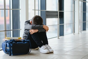 schoolboy crying in the hallway of the school, negative emotion