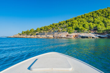 Boat sailing to rocky coast of Murter island in Dalmatia, Croatia - obrazy, fototapety, plakaty