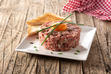 Beef steak tartare on rustic wooden table
