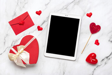 tablet for chooses gifts, makes purchase, envelope, box, two red hearts on marble table Top view Flat lay Holiday shopping list, Happy Valentine's day, party, online shop concept Mock up