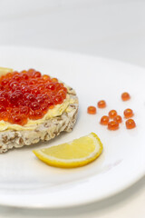 Crispy wheat crackers with red caviar, spread and lemon. Natural Diet Bread