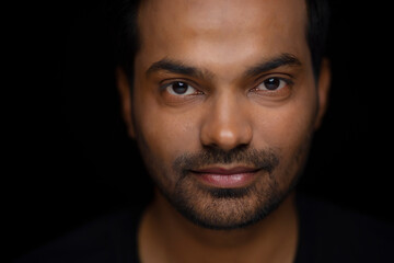 Obraz premium Close-up portrait of a young man against dark background
