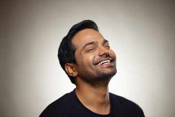 Obraz premium Portrait of a happy young man smiling with his eyes closed