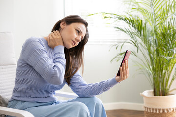 Young woman suffering from strong neck ache .