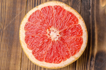Cut grapefruit half on wooden table.