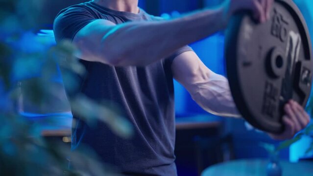 Headless male person spinning heavy plate burning shoulders exercise at home 4K