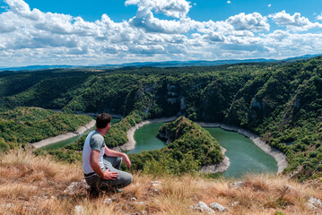 Fototapeta na wymiar Traveler Man at Uvac lake in Serbia Travel Lifestyle emotional concept adventure summer vacations outdoor hiking mountaineering harmony with nature