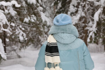 A woman in winter in a snowy forest rear view close-up background image