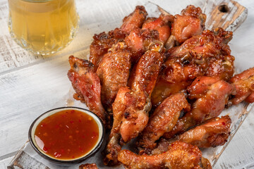 Chicken wings with sriracha sauce on wooden table