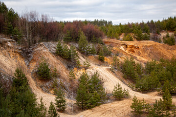 Textural sand, with  relief surface, multi-colored layers and different in size of granules, in outdoor sand career, after mining ore and sand for construction.