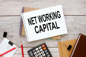 Net working Capital two notepads with text on a rustic background near a calculator and other supplies