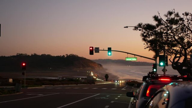 Defocused traffic lights, pacific coast highway 1, Torrey Pines state beach, Del Mar, San Diego, California USA. Road trip vacations. Roadtrip along ocean, freeway 101. Cars in evening twilight dusk.