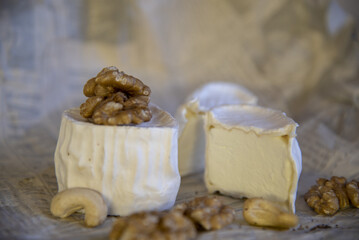Various types of cheese with white mold on packaging paper. Home production, natural products.