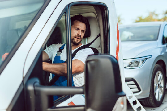 Handsome middle age man working in towing service on the road. Roadside assistance concept.