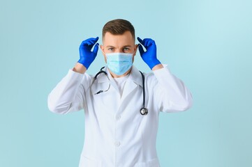 Male doctor in medical mask on color background