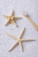 Fototapeta na wymiar A set of eco-friendly bamboo wooden toothbrushes with starfish on a white towel.