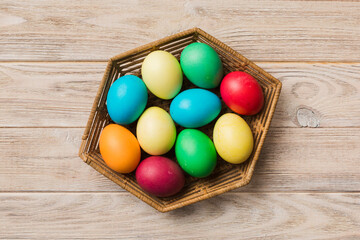 Multi colors Easter eggs in the woven basket on colored background . Pastel color Easter eggs. holiday concept with copy space